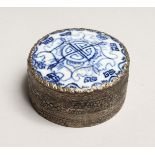 A CHINESE SILVERED CIRCULAR BOX AND COVER, blue and white porcelain top. 2.5ins diameter.