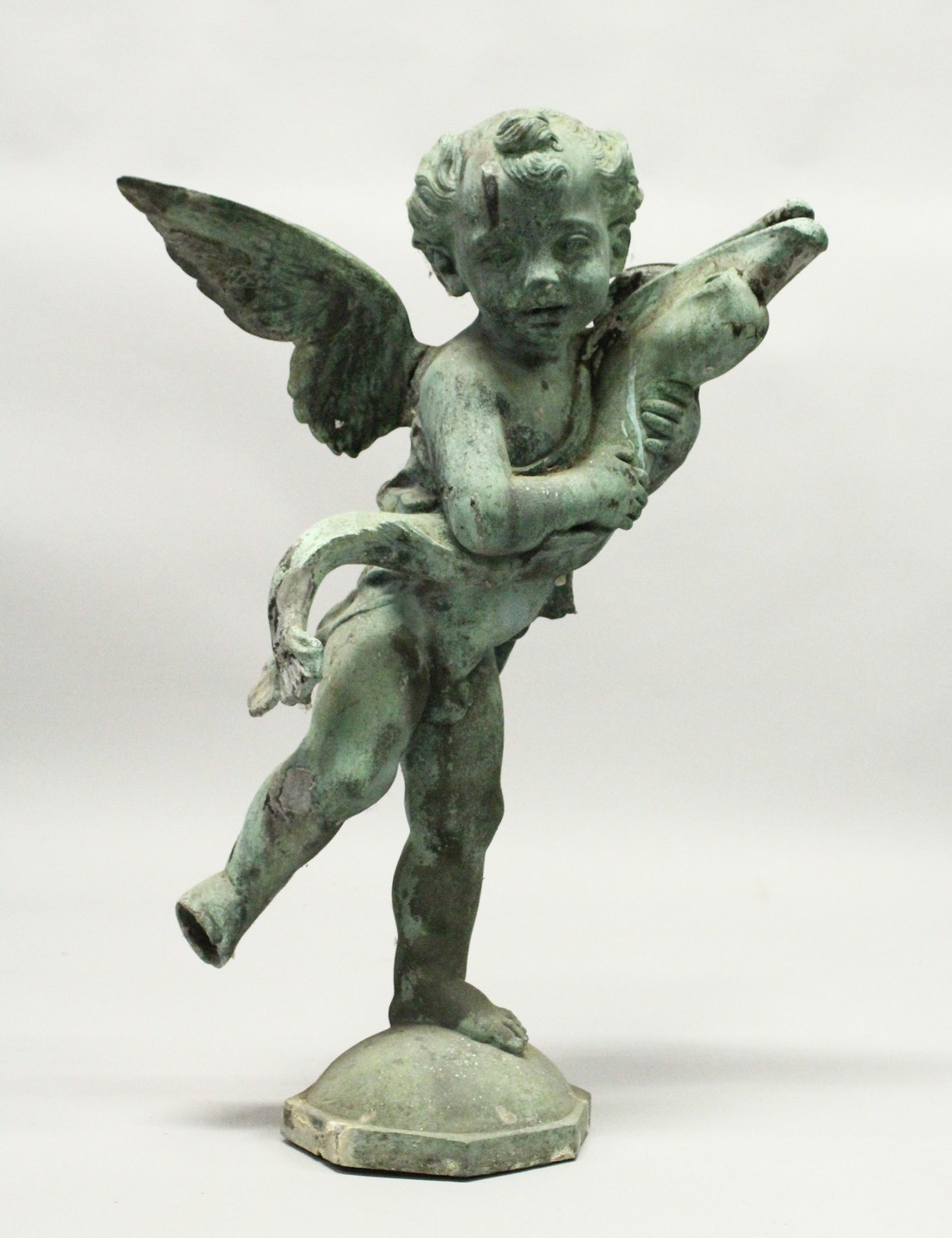 AN 18TH CENTURY LEAD FOUNTAIN as a winged cupid holding a fish, on an octagonal base. 2ft 5ins