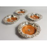 A VERY GOOD SET OF FOUR VICTORIAN SILVER WINE COASTERS with fruiting vine decoration and turned wood