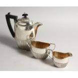 A THREE PIECE SEMI FLUTED TEA SET comprising tea pot, sugar basin and milk jug Birmingham 1915.