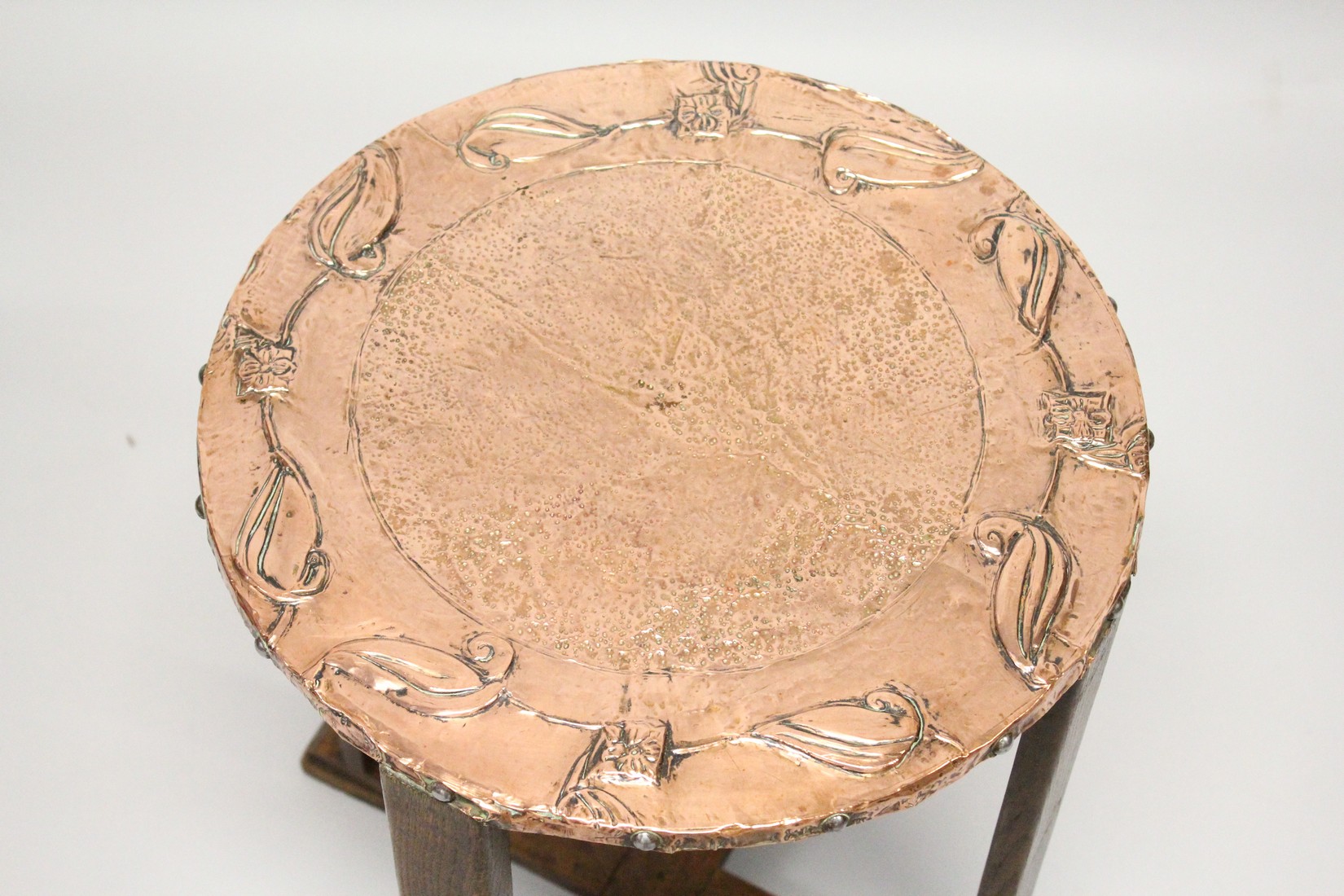 A GOOD ART NOUVEAU COPPER TOP CIRCULAR TABLE on four legs with cross stretchers 1ft 8ins high, 1ft - Image 2 of 4