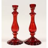 A PAIR OF RUBY GLASS CANDLESTICKS 8.5ins high