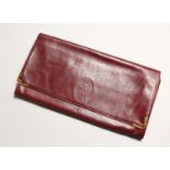 A CARTIER RED LEATHER FOLDING CLUTCH BAG used, 11ins wide.