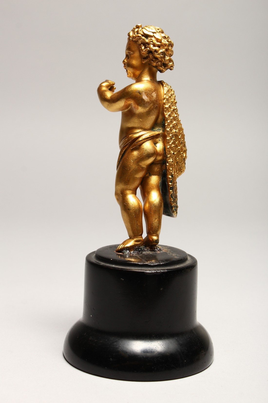 A GOOD SMALL GILDED METAL MODEL OF A CHERUB, standing with a cloak draped over one shoulder, on a - Image 3 of 3