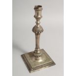 A SINGLE GEORGE II CAST CANDLESTICK by John Care on a square gadrooned base 10.5ins high, weight