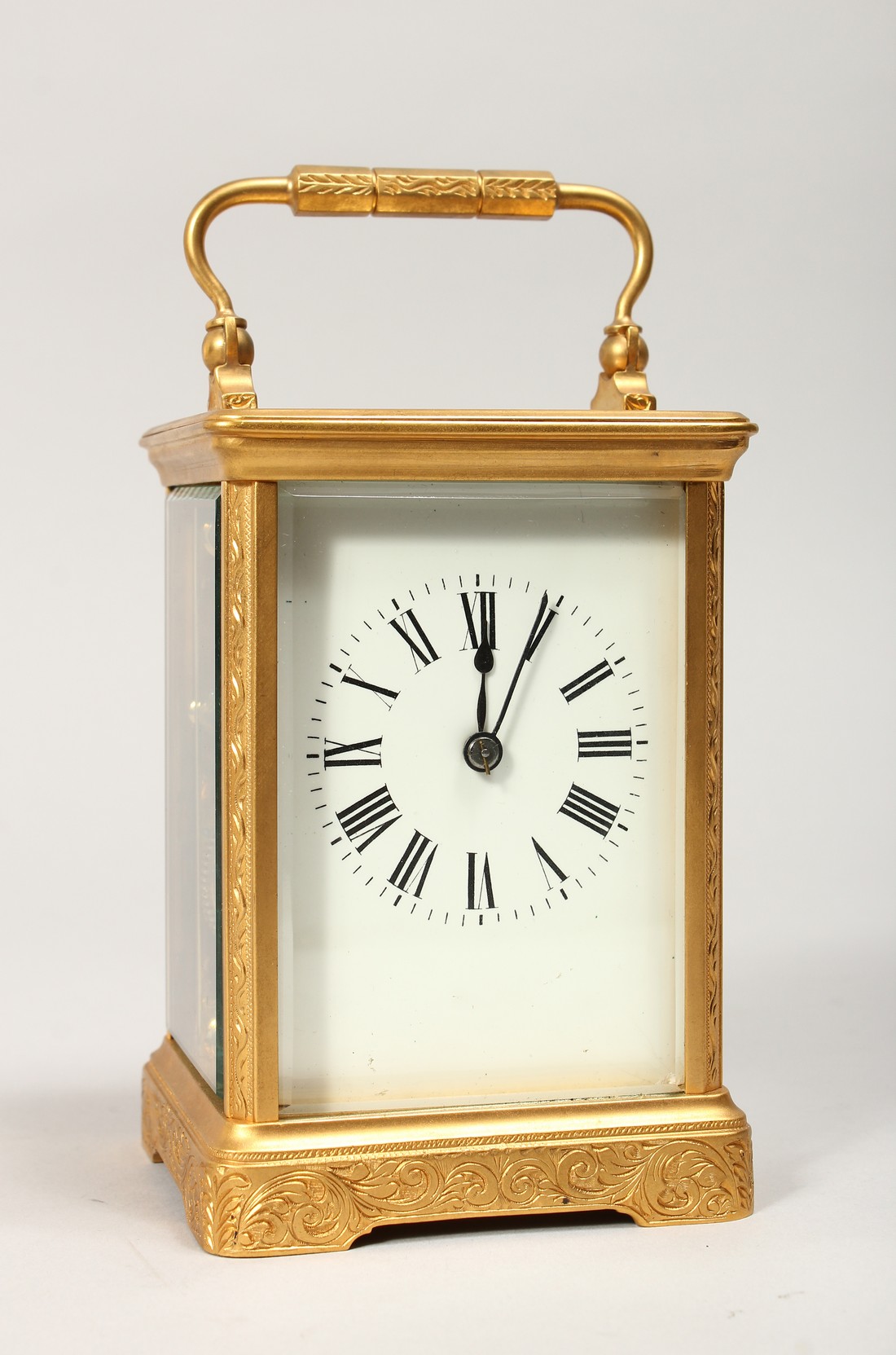 A GILT BRASS CARRIAGE CLOCK, with white enamel dial, roman numerals, the movement striking on a