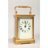 A GILT BRASS CARRIAGE CLOCK, with white enamel dial, roman numerals, the movement striking on a