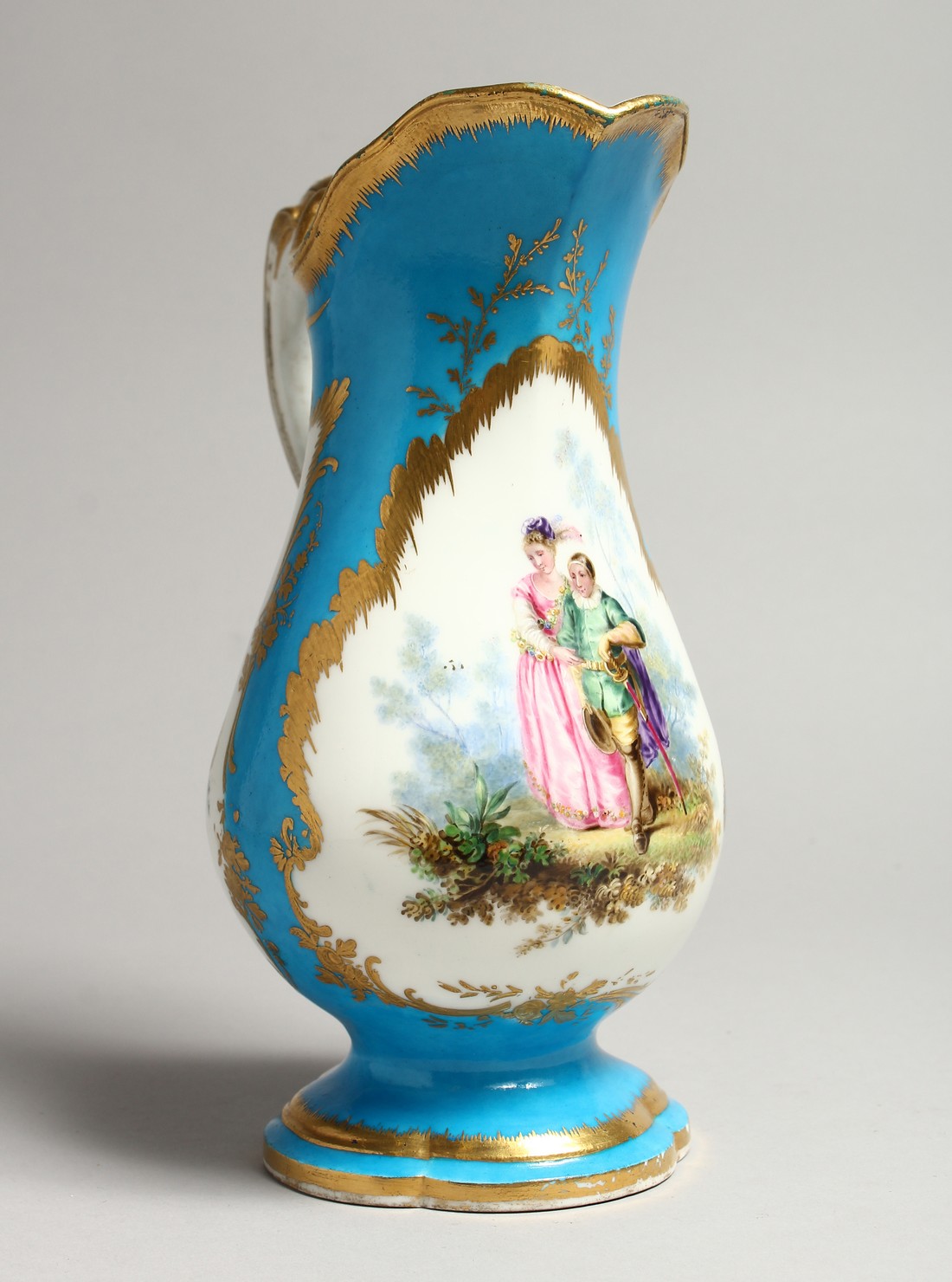 A GOOD SEVRES PORCELAIN EWER, blue ground edged in gilt and painted with three panels of figures and