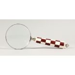 A MAGNIFYING GLASS WITH CHEQUERED HANDLE.