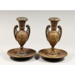 A PAIR OF ORNATE LATE 19TH CENTURY ITALIAN BRONZE URN SHAPED CANDLESTICKS, on circular bases, cast