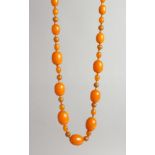 AN AMBER TYPE BEAD NECKLACE with seven large beads and numerous small beads.