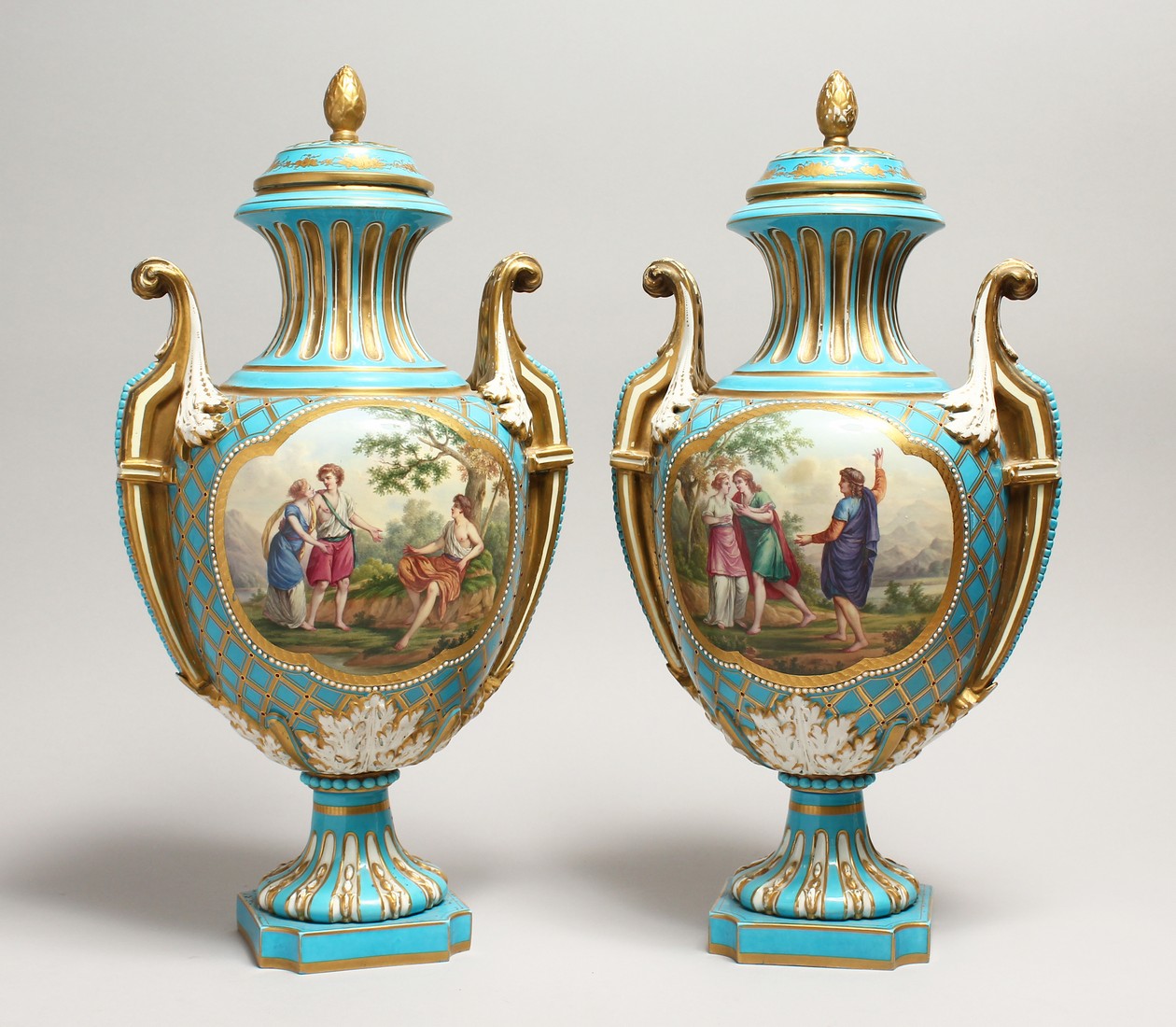 A SUPERB LARGE PAIR OF SEVRES TWO HANDLED URN SHAPED VASES AND COVERS, blue ground edged in gilt and