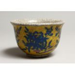 A CHINESE CRACKLEGLAZE TEA BOWL, yellow ground painted with fruit 3.5ins diameter.