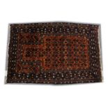 A BELUCHI PRAYER RUG, rust ground with stylised geometric design 5ft x 3ft 5ins