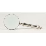 A MAGNIFYING GLASS WITH CHROME HANDLE.