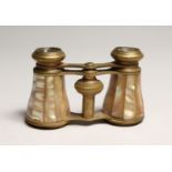 A PAIR OF MOTHER OF PEARL AND GILT OPERA GLASSES 4ins long in a leather case.