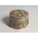 A CHINESE SILVER CIRCULAR BOX AND COVER, repousse decorated with flowers 3ins diameter