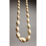 A DELICATE CARVED GRADUATED IVORY NECKLACE of forty one beads 14ins long.