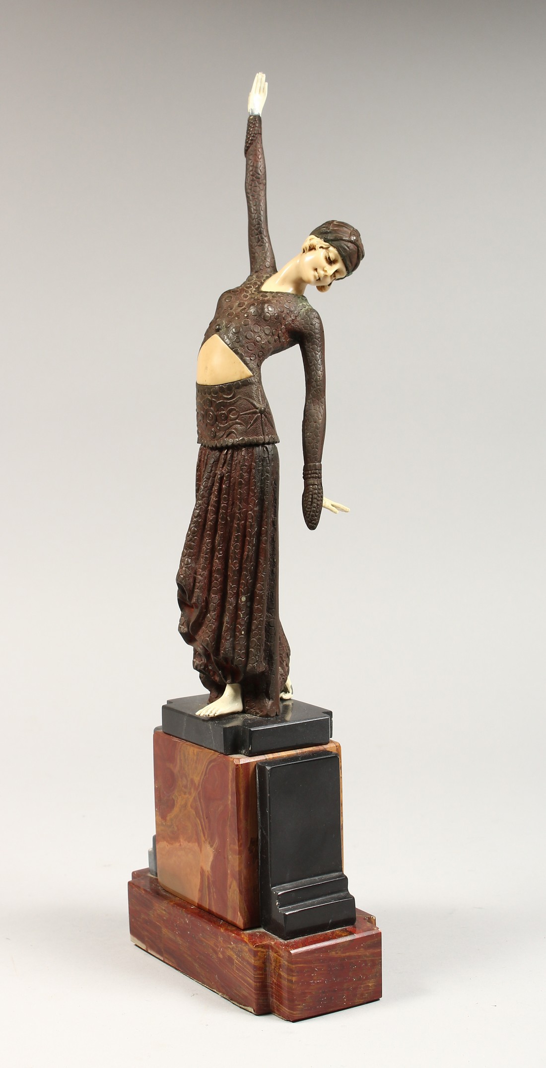 AN ART DECO STYLE FIGURE OF A LADY, arm outstretched, on a stepped marble base 16ins high.