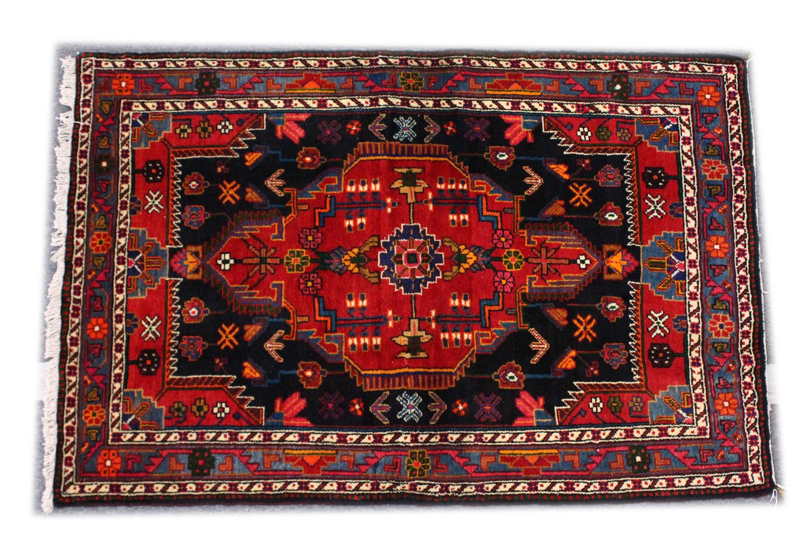 A GOOD PERSIAN RUG, 20TH CENTURY, red ground with stylised decoration. 5ft 4ins x 3ft 6ins