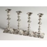 A GOOD SET OF FOUR GEORGIAN STYLE CANDLESTICKS on a leaded base 24cms high Birmingham 1904, Maker I.