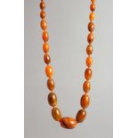 AN AMBER TYPE BEAD NECKLACE with forty six graduated beads