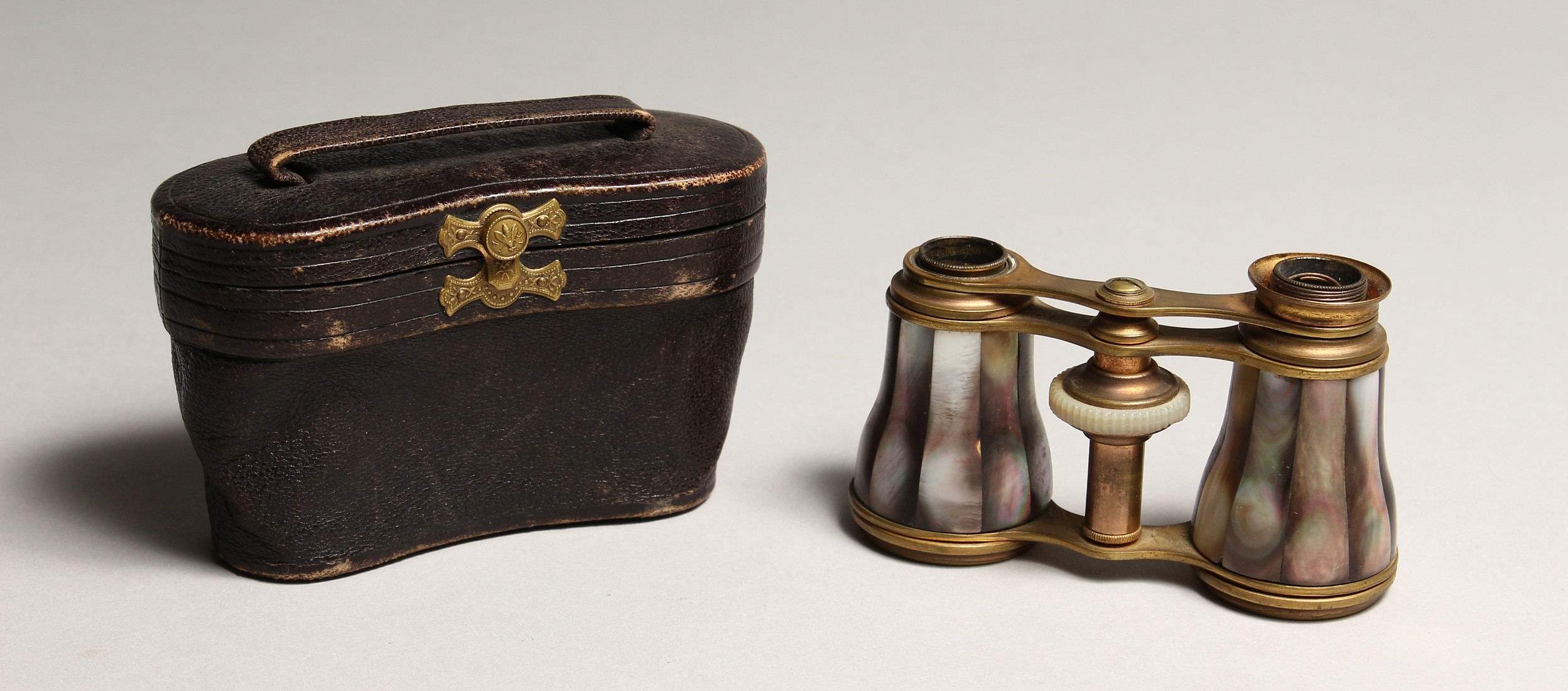 A PAIR OF MOTHER OF PEARL AND GILT OPERA GLASSES 4ins in a leather case.