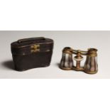 A PAIR OF MOTHER OF PEARL AND GILT OPERA GLASSES 4ins in a leather case.
