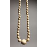 A GOOD GRADUATED IVORY BEAD NECKLACE on one hundred beads 29ins long