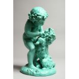 A CONTINENTAL TURQUOISE GLAZED POTTERY FIGURE of a young girl playing with a dog. 11ins high.