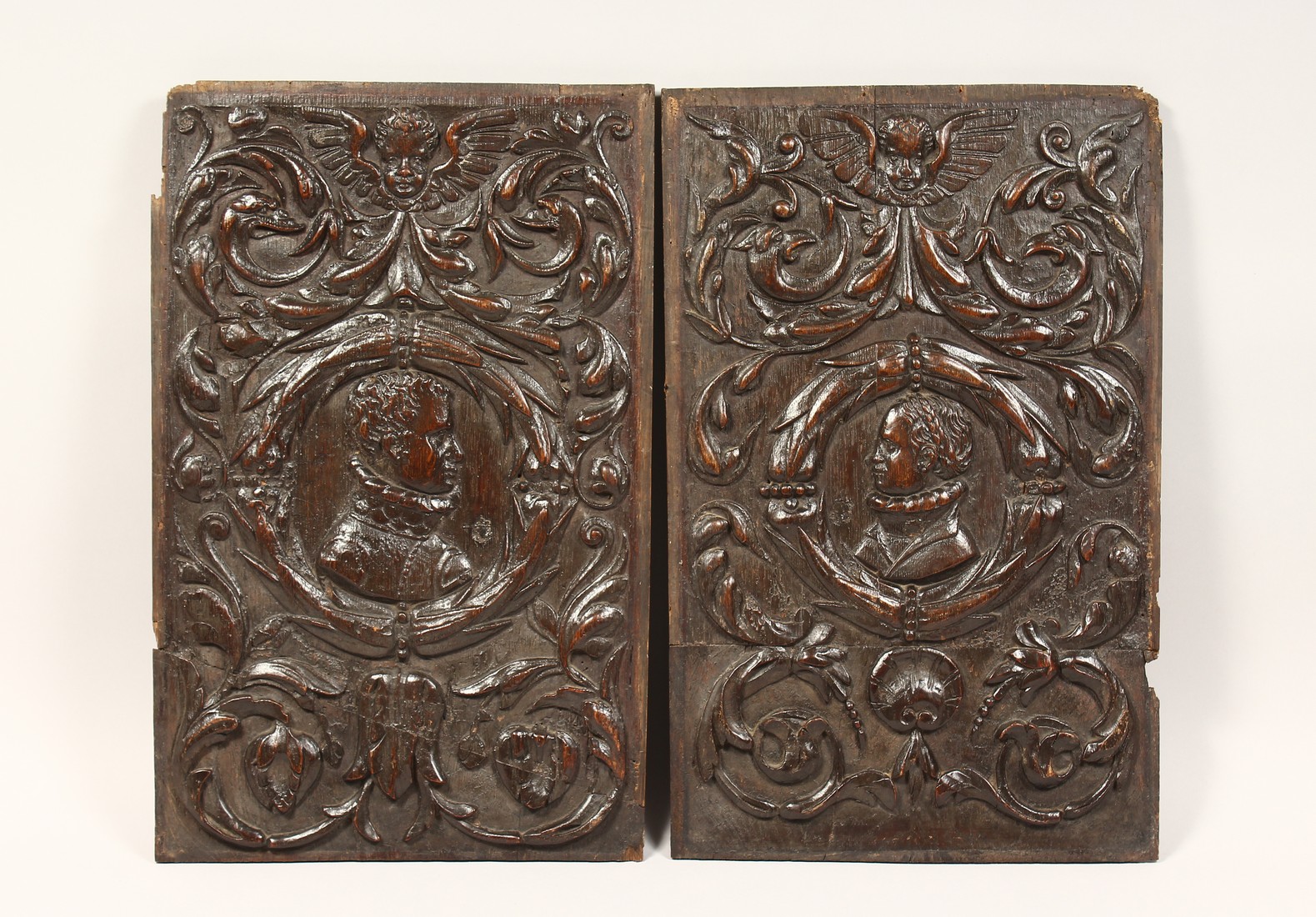 A GOOD PAIR OF ROMAN CARVED WOOD PANELS 19ins x 12ins.