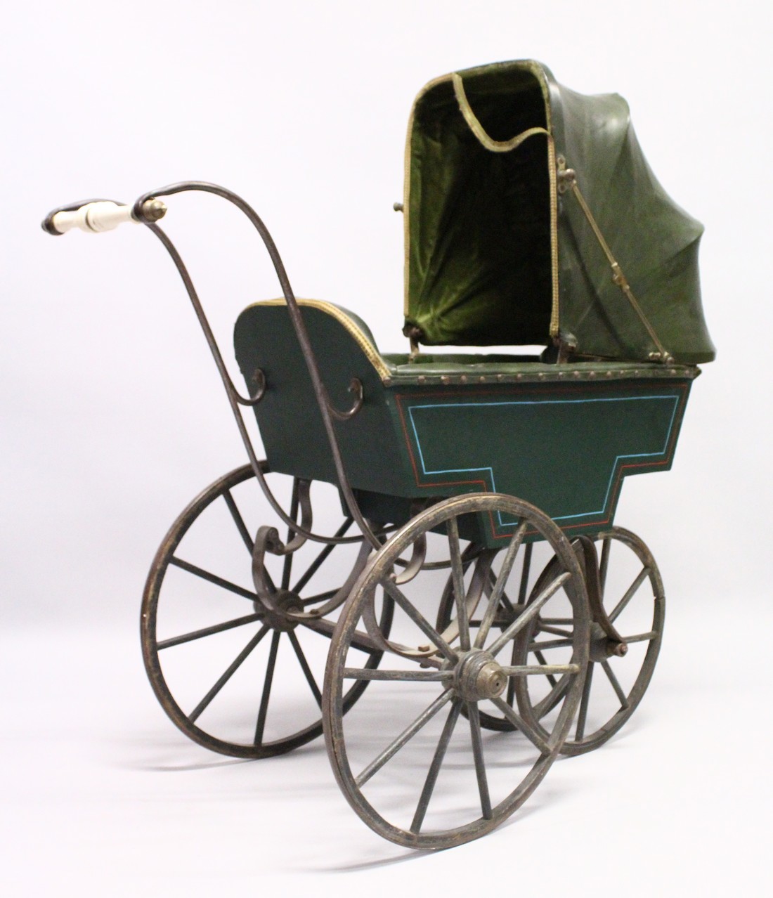 A RARE VICTORIAN METAL, WOOD AND LEATHER PRAM with folding hood, porcelain handles, wooden wheels.