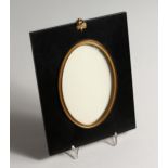 AN EBONISED AND GILT METAL MOUNTED OVAL FRAME, Aperture size 6ins x 4ins