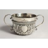 A QUEEN ANNE TWO HANDLED CIRCULAR PORRINGER, wrythen fluted handles, London 1709, maker J. JACKSON