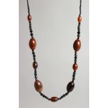 A RHINO BEAD NECKLACE with eight various beads and facet glass beads.