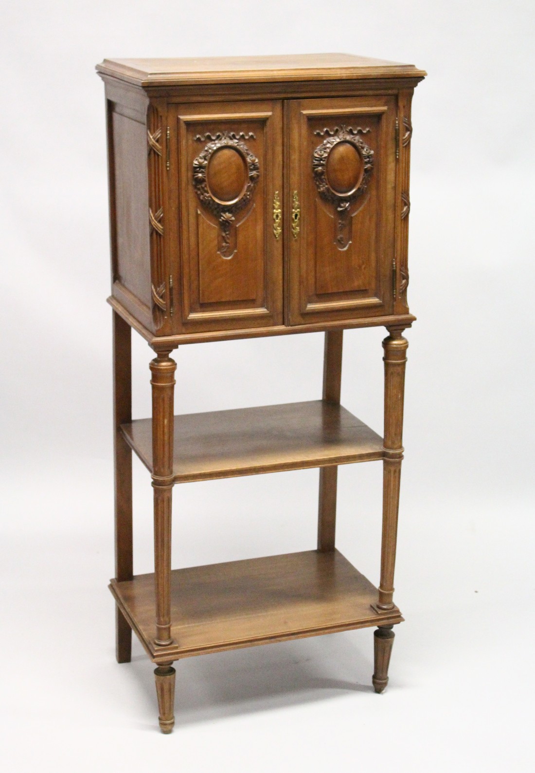 A LATE 19TH CENTURY FRENCH WALNUT MUSIC CABINET, with a pair of carved panelled doors enclosing