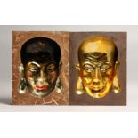 A PAIR OF CHINESE WOODEN PORTRAIT PICTURES with inset heads in gilt 12ins x 9.5ins