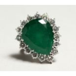 A SUPERB 18CT WHITE GOLD TIER DROP EMERALD AND DIAMOND RING set with a large emerald surrounded by