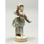 A GOOD MEISSEN PORCELAIN FIGURE OF A GIRL holding a garland of flowers, on a circular base. Cross