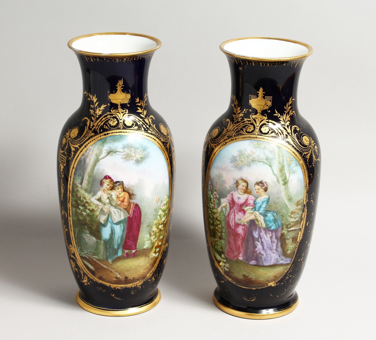 A SUPERB LARGE PAIR OF SEVRES PORCELAIN VASES rich deep blue, painted with a large panel of girls,