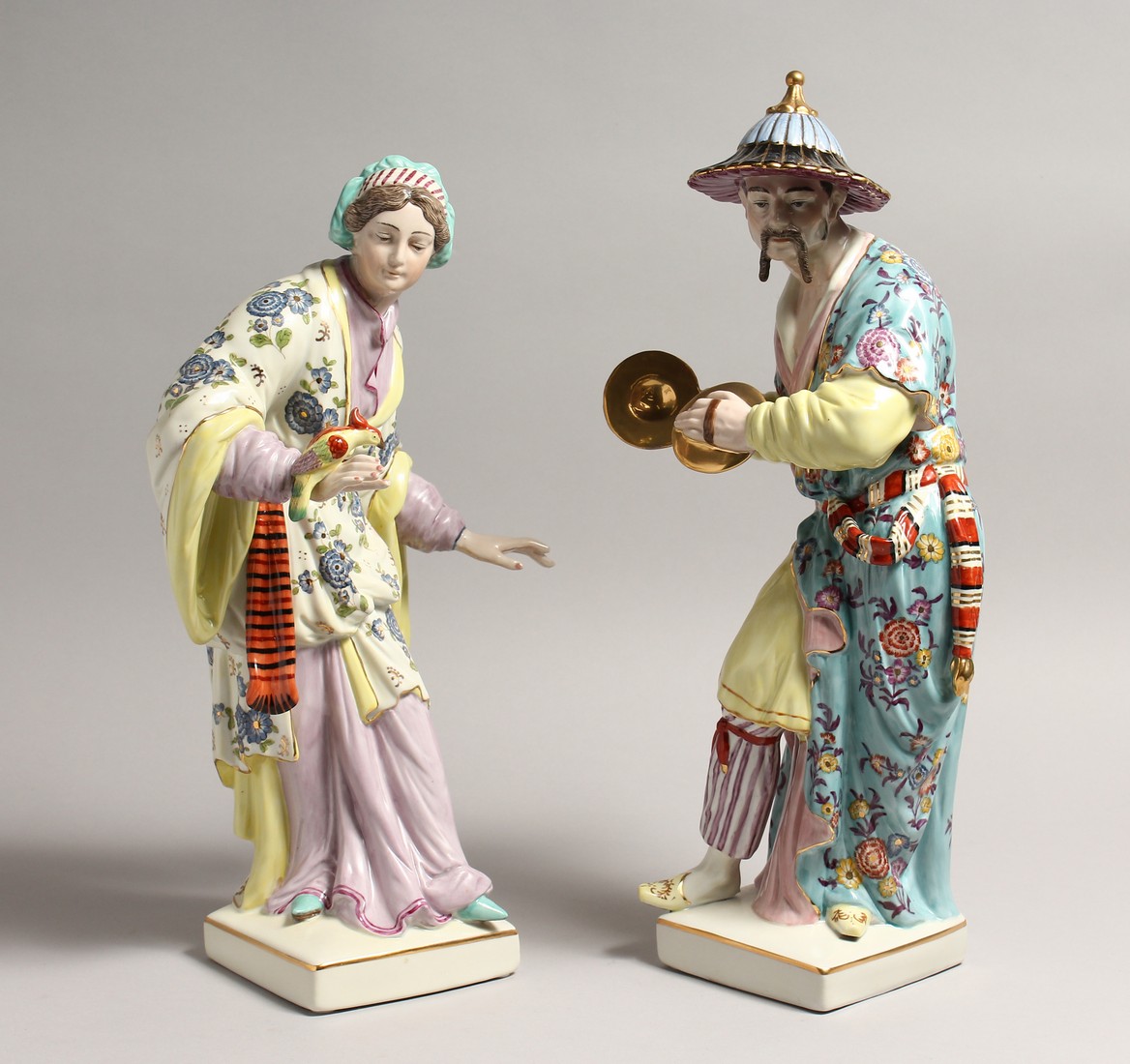 A PAIR OF PORCELAIN FIGURES OF A CHINESE MAN AND WOMAN ON SQUARE BASES 15ins high