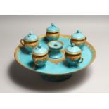 A CONTINENTAL LIGHT BLUE PORCELAIN CIRCULAR TURKISH - ISLAMIC DRINKS SET with gilt decoration,