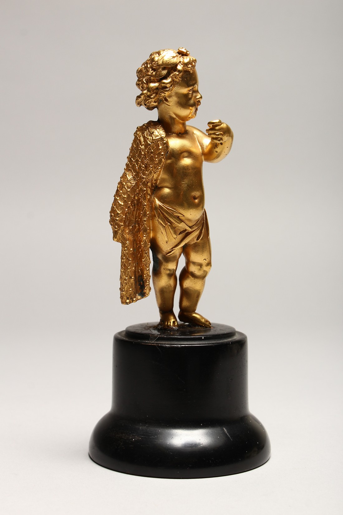 A GOOD SMALL GILDED METAL MODEL OF A CHERUB, standing with a cloak draped over one shoulder, on a - Image 2 of 3