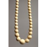 A GOOD GRADUATED IVORY BEAD NECKLACE on ninety beads 28ins long.