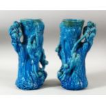 A PAIR OF CHINESE TURQUOISE GLAZED POTTERY MONKEY VASES, the body of each formed as a tree trunk