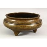 A CHINESE BRONZE CIRCULAR CENSER, supported on three feet, 16cm diameter.