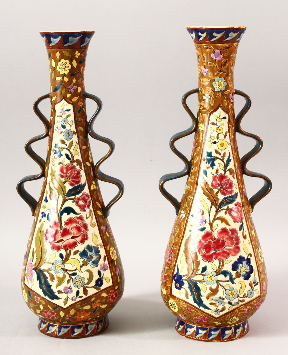 A PAIR OF IZNIK STYLE TAPERING VASES, with wavy handles, 36cm high.