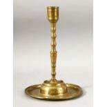 AN 18TH CENTURY OTTOMAN ENGRAVED BRASS CANDLESTICK, the base with a band of calligraphy, 25.5cm.