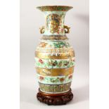 A LARGE CHINESE TWIN HANDLE CELADON GROUND ENAMELLED VASE AND STAND, the body painted with various