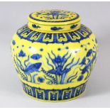 A CHINESE YELLOW GROUND PORCELAIN JAR AND COVER, the painted with fish amongst aquatic flora, 14cm